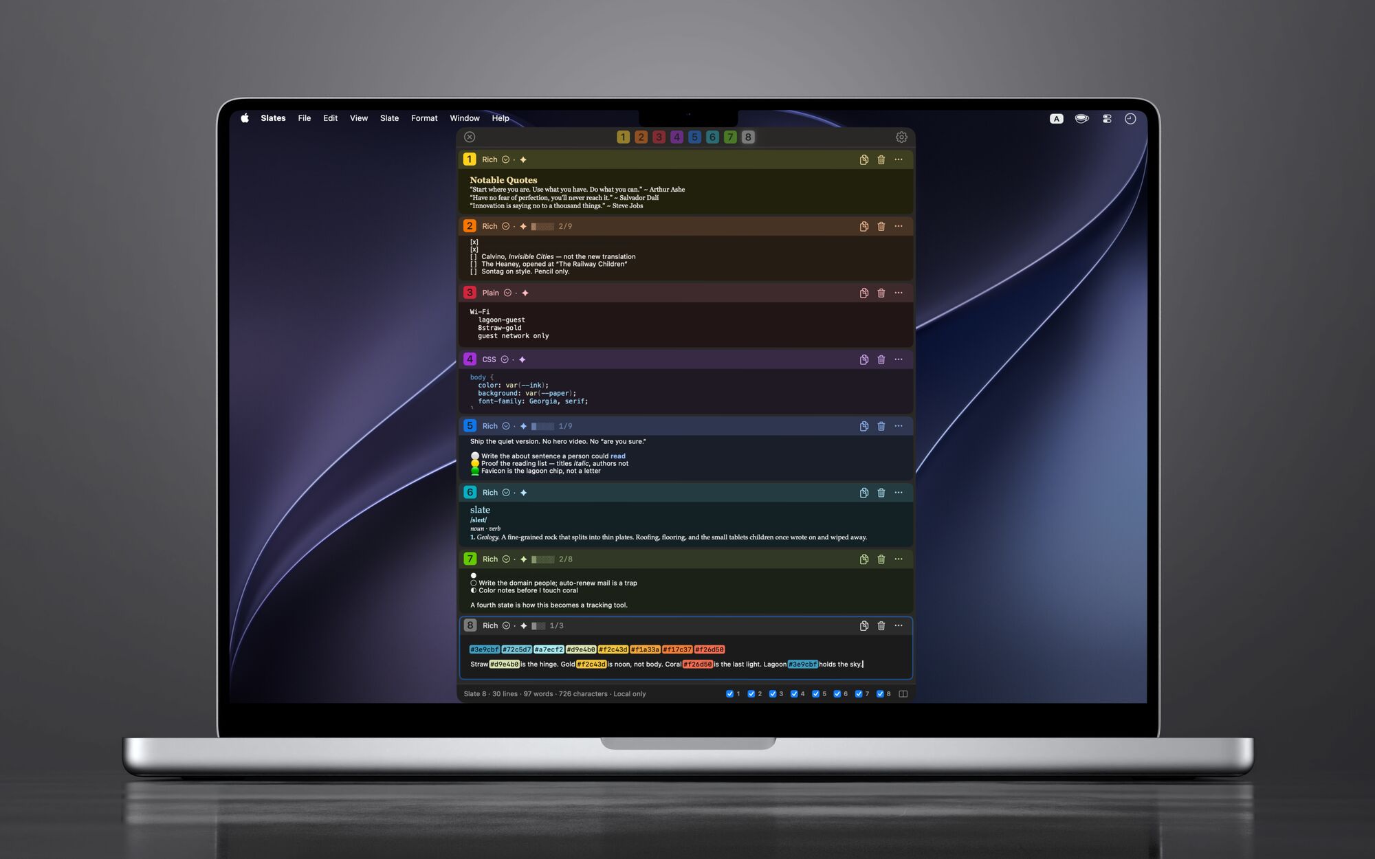 A MacBook Pro on a dark, reflective surface, running Slates: one window with all eight colored slates in a vertical list, from a yellow page of notes to a gray palette of sunset colors.