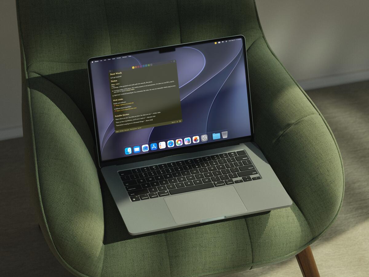A MacBook Air on a green velvet armchair in soft daylight, Slates open to a single yellow slate in focus.