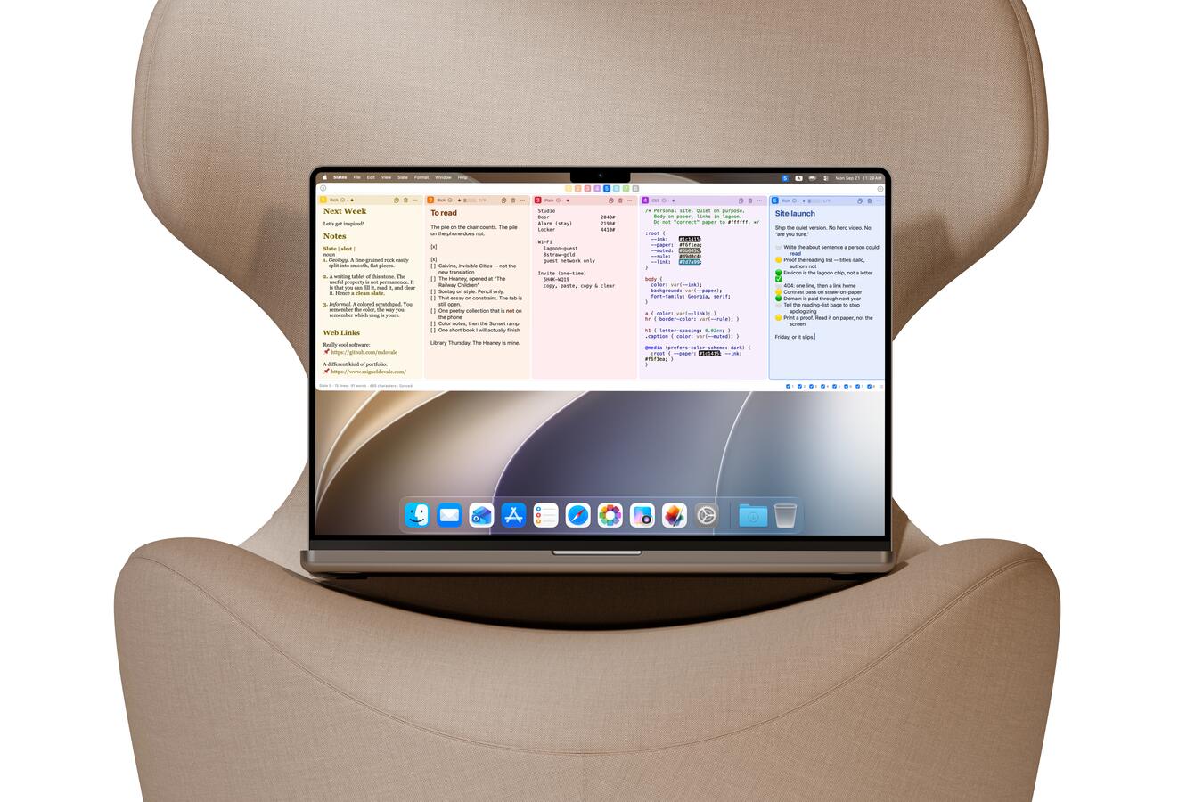A MacBook Pro 14-inch cradled in a beige wingback chair, Slates showing a horizontal strip in Light.