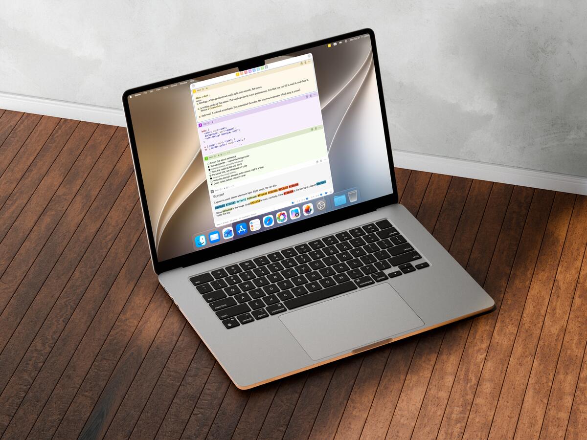 A MacBook Air on a sunlit wooden floor, Slates showing its vertical list of colored slates in Light.